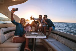 Young adultts having fun on a boat during sunset, Promarine finance